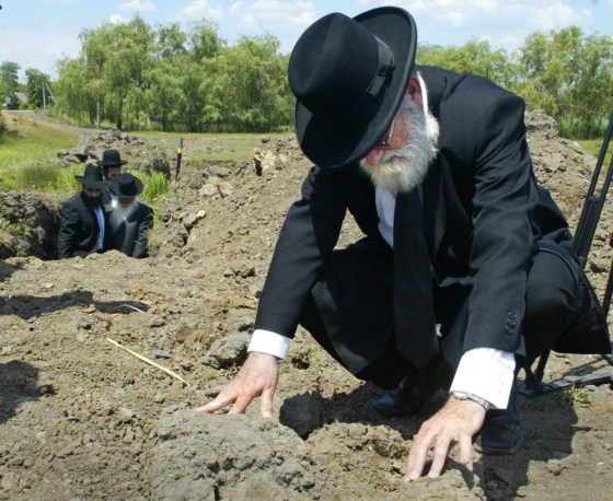 A rabbi from Israel checks the land at what Jewish leaders say is a mass grave of Jews slaughtered in Ukraine during World War II, in the village of Gvozdavka-1, on Monday, June 11.