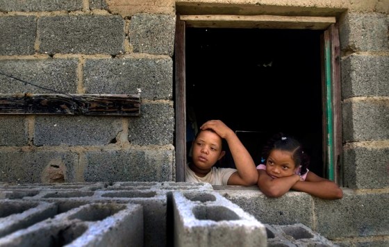 Two children look out on June 15 from their home in Haina, Domincan Republic, a town considered among the world's most polluted.