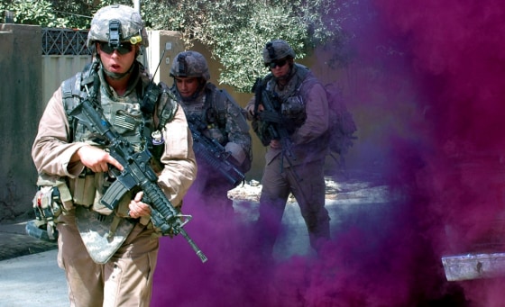 Soldiers with the 3rd Stryker Brigade Combat Team, 2nd Infantry Division, use a smoke grenade for concealment while moving to their next location in Baqouba, Iraq, on Tuesday. They are part of the offensive pushing out from Baghdad.