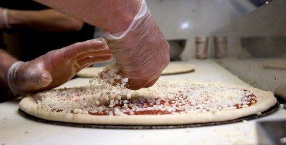 Sharply rising cheese prices has pizza restaurant owners watching the cheese on their pizzas like this one being prepared at Constantly Pizza in Concord, N.H.