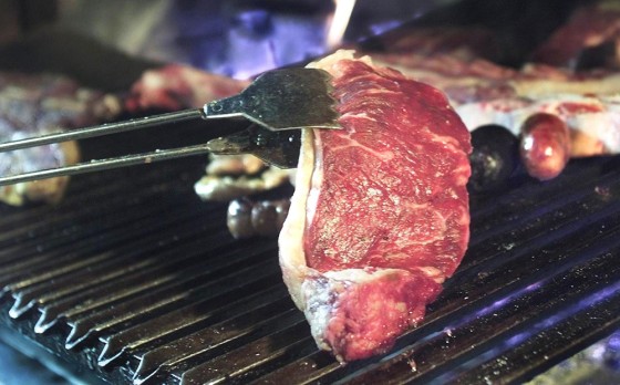 A steak of Argentine beef is put on the grill of a
