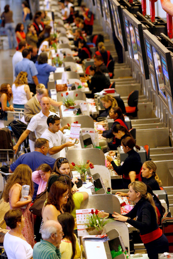 Tam Airlines employees check-in passengers at the international airport in Brasilia on Wednesday.