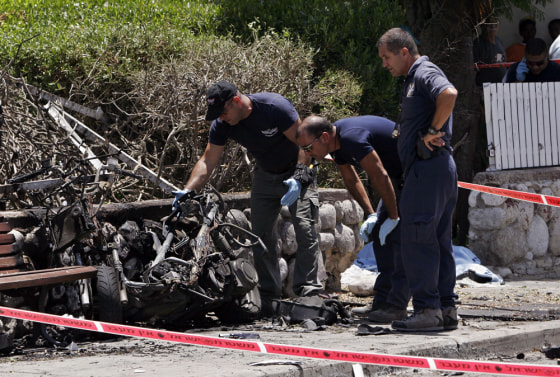 Israeli police officers examine a motorcycle that exploded, killing Arik Korkus, 33, a criminal and a former elite infantry soldier, in the town of Ashkelon on June 27. Israel's rival underworld gangs have been waging a bloody battle for years over gambling operations and other lucrative businesses, targeting each other with bullets, bombs and anti-tank missiles.