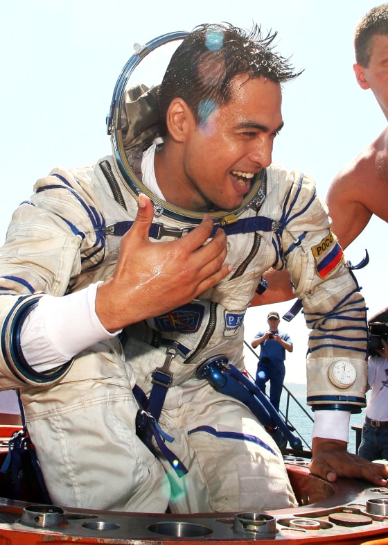 Malaysian astronaut candidate Shukor climbs out of a space capsule during training outside the Crimean Black Sea city of Sevastopol