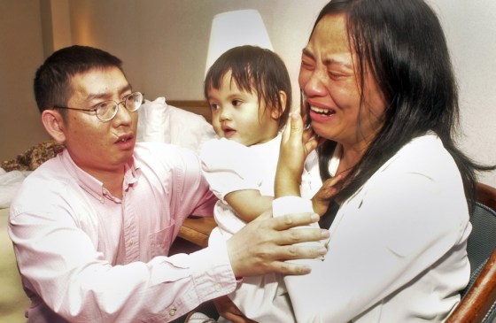 Shaoqiang He, left, comforts his wife, Qin Luo He, as she holds their daughter, Avita He, in their hotel room in Memphis, Tenn., on May 12, 2004. Avita He, now named Anna Mae He, has been returned to her parents' custody.