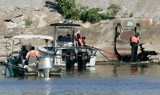 Firefighters search a culvert on the Mississippi River in St. Paul, Minn., Friday after two workers vanished from a sewer when a flood surge rushed through. According the National Weather Service, nearly a half-inch of rain fell in about 30 minutes.