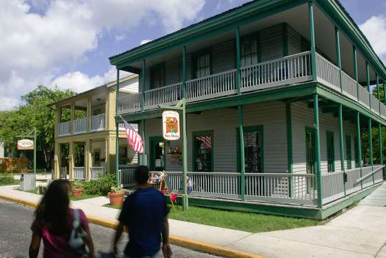 Tourists walk past The Cuna Street Toy Shop, right, and Knock on Wood, two historic buildings on Cuna Street in the historic section of St. Augustine, Fla. The two shops are housed in two of dozens of historic buildings the University of Florida will be maintaining for the City of St. Augustine, Fla. The maintenance and upkeep of the building has become too expensive for the nation's oldest city.