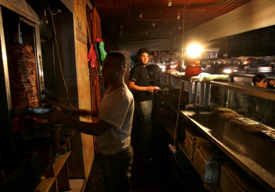 Palestinians use propane to light their restaurant in Gaza City on Sunday after the electricity was cut.