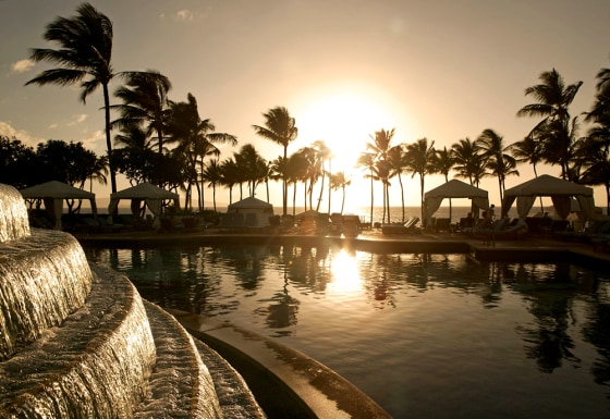 A view of the sun setting poolside from the Grand Wailea Resort, in Wailea, Maui, Hawaii.