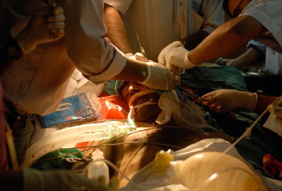 Medics treat a person injured in a bomb blast at a hospital near Lumbini Park