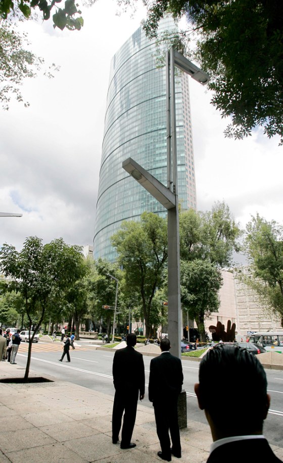 People stand in front of the 55-floor Torre Mayor building after a bomb warning in Mexico City on&nbsp;Thursday.