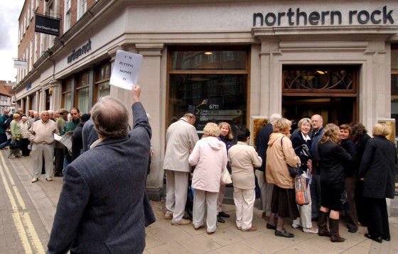 Customers line up outside a branch of the British mortgage lender Northern Rock in York England, as savers across the country seek to remove their money from the crisis-hit bank. One investor walks to the back of the queue to make a deposit. Treasury Secretary Alistair Darling sought to assure the bank's depositors that their money was safe, though former U.S. Federal Reserve Board chairman Alan Greenspan warned of difficulties ahead in Britain's booming housing market.