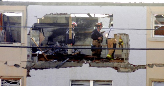 Florida firefighters examine a three-story apartment building, which was home to up to 150 residents, that caught fire after an explosion Thursday.