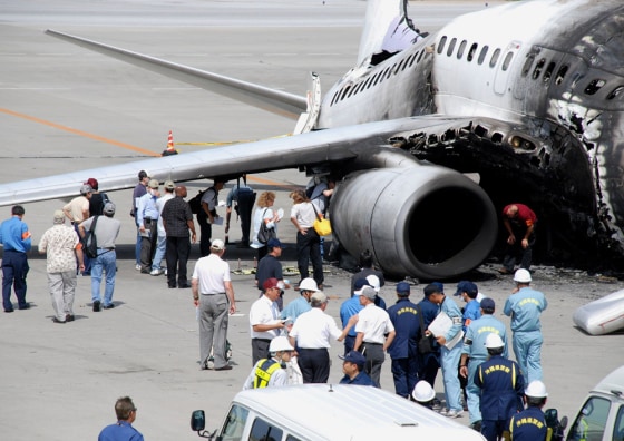Japanese and U.S. investigators including Boeing officials, inspect the burned-out engine of Taiwan's China Airlines 737-800 jet liner that exploded after landing at the Naha airport in Japan's southern island of Okinawa, on Aug. 23. On Thursday, airport workers in Japan found a 28-inch fracture in the fuselage of a similar China Airlines Boeing 737-800.