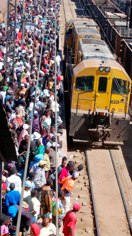 Zimbabweans wait for a domestic train in Harare, Zimbabwe, as the newly-appointed finance mnister massively devalues the local dollar in a bid to attract scarce foreign currency