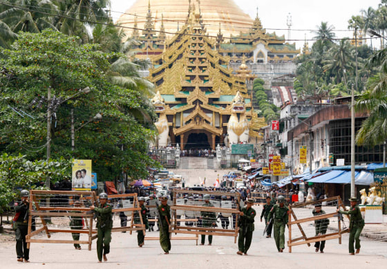 Military officials set up barricades after halting monks from entering the Shwedagon Pagoda in Yangon