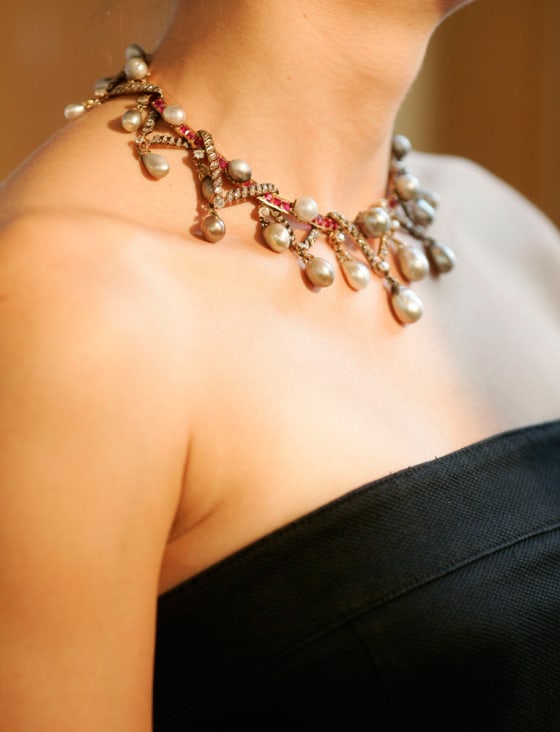 Christie's auction house employee Linda Pyke is reflected in a mirror while wearing a pearl, diamond and ruby necklace made of pearls once owned by Marie Antoinette.