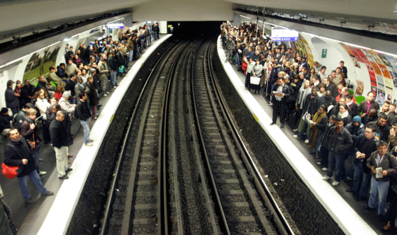 Subway users wait for a train in Paris on Friday. Train, subway and bus travel around France remained a tangle as Paris transit workers continued their walkoutover President Nicolas Sarkozy's economic reforms.
