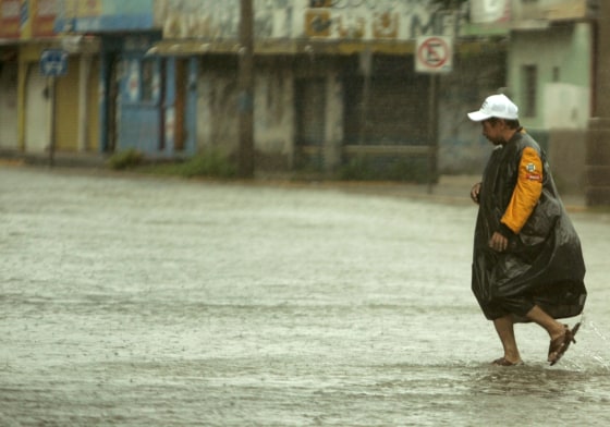 A man tries to cross a flooded street of Mazatlan, Mexico, on Saturday, after Hurricane Lane slammed into a sparsely populated stretch of Mexico's Pacific coast.