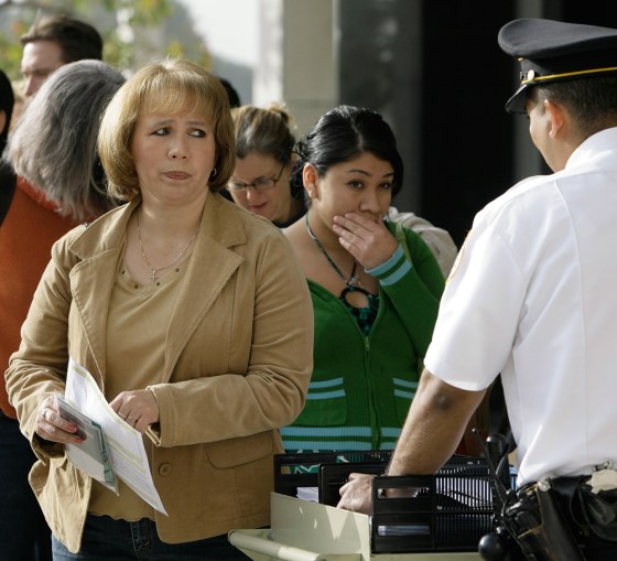 A passport seeker looks at an immigration official outside the U.S. Federal Building in Los Angeles, March 16. Overwhelmed by unprecedented demand, the State Department says the crush of new applicants has inundated its staff and caused delays of up to a month-and-a-half at the peak January-to-April season when many people are preparing to travel over the spring and summer.