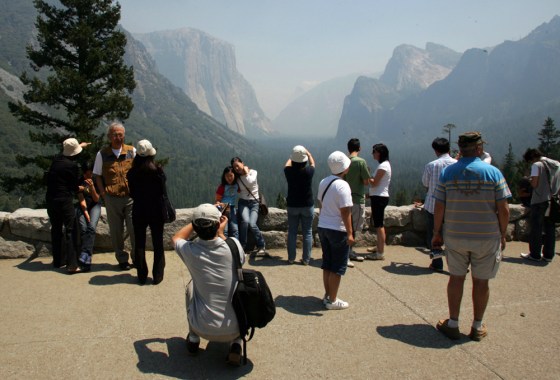 Image: Tourists stop to take photos of El Capitan and the Half Dome in Yosemite.