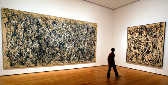 A visitor strolls by the artwork of Jackson Pollock at the Museum of Modern Art in New York.