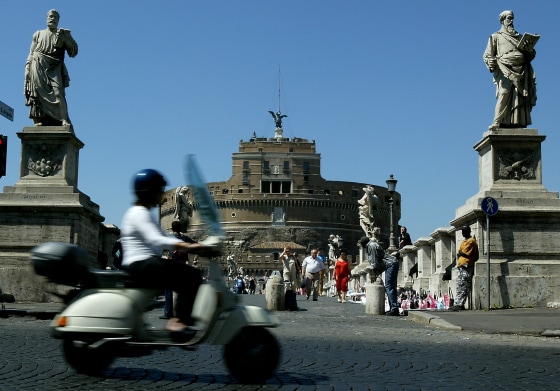 Woman Rides a Scooter as she Passes the Castel Sant'Angelo
