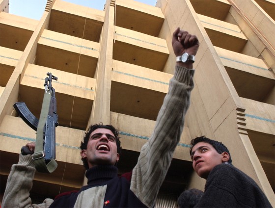 An Iraqi man holds an AK-47 while celebrating news of the capture of former Iraqi leader Saddam Hussein in downtown Baghdad Sunday. Analysts said they expect Iraq's security situation to eventually improve, thus improving the climate for business.