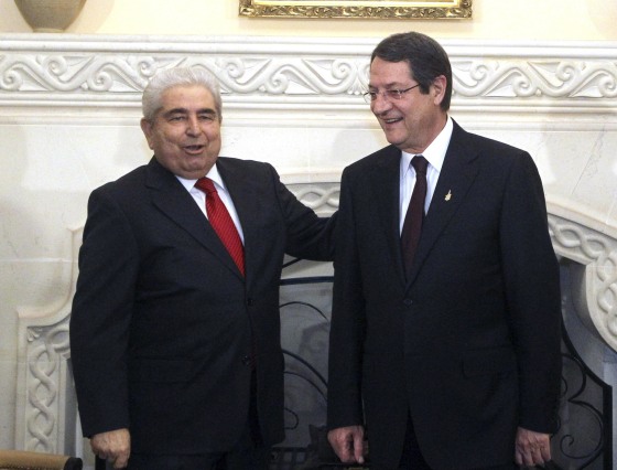 Image: Cypriot President Nicos Anastasiades (right) stands next to his predecessor Demetris Christofias