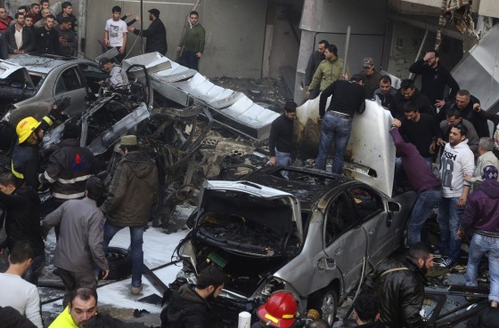 Image: People gather at the site of an explosion in Beirut's southern suburbs