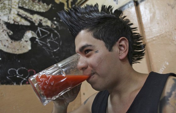 A young man drinks a glass of pulque, the traditional native beverage of Mexico.