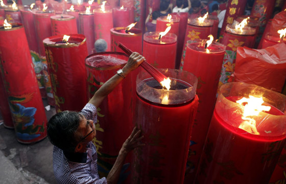 An Indonesian ethnic Chinese man burns incense sticks during Lunar New Year celebrations at a temple in Jakarta, Indonesia on Jan. 31. The Year of the Horse, according to the symbol of the 12 year cycle of animals, begins today.