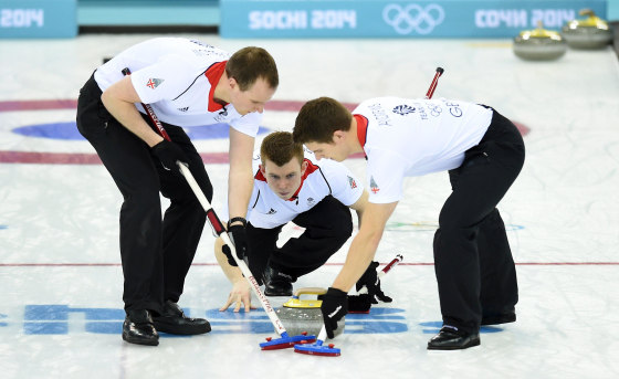 Great Britain's Scott Andrews and Michael Goodfellow brush the ice surface after Greg Drummond threw the stone during the Men's Curling Gold Medal Game between Canada and Great Britain at the Ice Cube Curling Center in Sochi during the Sochi Winter Olympics on Feb. 21, 2014.
