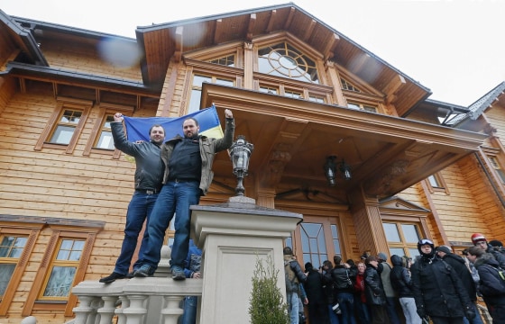 Ukrainians wave a national flag as they pose in front of the residence of Ukrainian President Viktor Yanukovych in the village of Mezhyhirya, near the capital Kiev on Saturday. Protesters took full control of the Yanukovych residence and opened the premises to the public and the media.