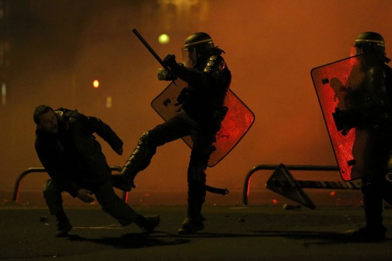 Image: A protester is kicked by a French CRS riot policman after clashes during a march in Nantes, western France