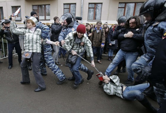 Police detain protesters outside a courthouse in Moscow February 24, 2014. Russian police detained dozens of protesters on Monday outside a Moscow courthouse where a judge was expected to sentence eight defendants convicted of attacking police at a 2012 demonstration against President Vladimir Putin.