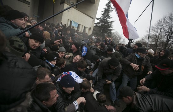 Image: Ukrainian men help pull one another out of a stampede during clashes at rallies held by ethnic Russians and Crimean Tatars in Simferopol