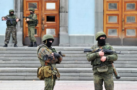 Image: Unidentified armed and uniformed men guard the Crimean Cabinet of Ministers building in Simferopol