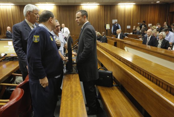 Olympic sprinter Oscar Pistorius talks to his defense team after arriving at the High Court in Pretoria, South Africa, on Tuesday.
