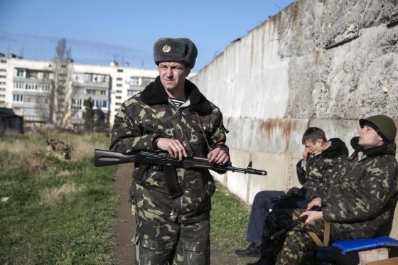 Image: A Ukrainian serviceman stands guard on the territory of a military unit located in the village of Lyubimovka, Crimea