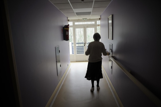 A woman, suffering from Alzheimer's desease, walks in a corridor on March 18, 2011 in a retirement house in Angervilliers, eastern France.