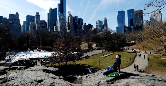 Roberto Serrano, of New York, sunbathes while sitting in Central Park in New York City on March 11, 2014.
