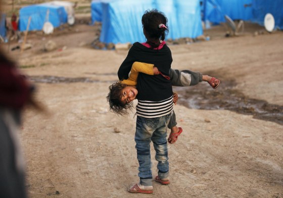 Image: Syrian refugee girls play outside tents in the southeastern city of Kilis near the Syrian-Turkish border