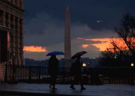 People carry umbrellas as they walk out of the US Capitol, on March 12, 2014 in Washington, DC. The Washington area was hit with a fast moving storm causing temperatures to drop. 