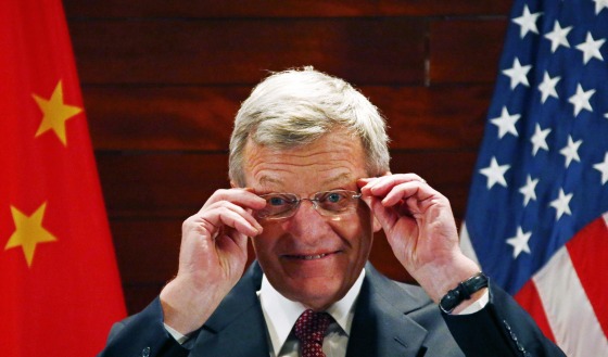Image: U.S. Ambassador to China Baucus adjusts his glasses in front of Chinese and American national flags during a news conference at the U.S. Embassy, upon his arrival to his new post, in Beijing