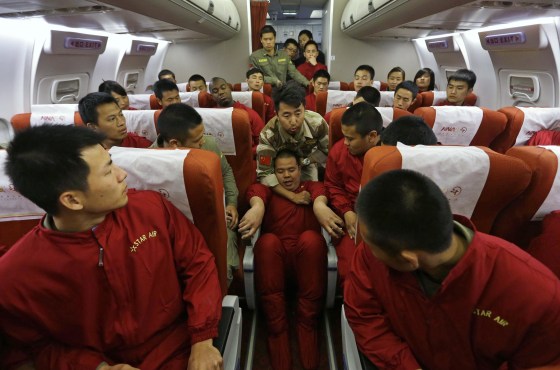 Image: An instructor holds a student by his neck during a special course on flight safety on the outskirts of Beijing