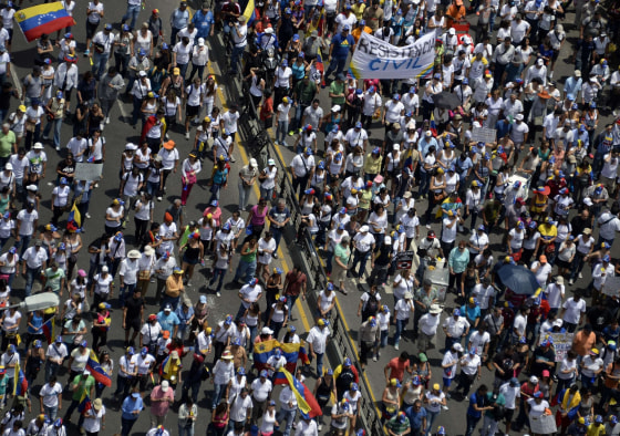 Opposition activists march toward the Cuban embassy to protest against Cuban interference in Venezuela's internal affairs