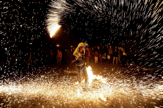 An Iranian man lights fireworks during a celebration known as “Chaharshanbe Suri,” or Red Wednesday, marking the eve of the last Wednesday of the solar Persian year, in Pardisan Park, Tehran on Tuesday.