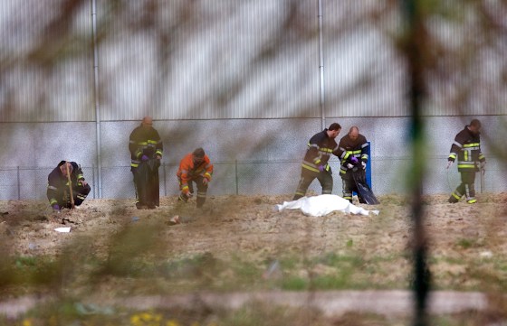 Emergency personnel remove evidence near a covered body after a World War One armament exploded in Ypres, Belgium on Wednesday, March 19, 2014.