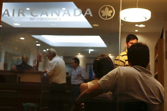 Image: Customers wait their turn to be served at the Air Canada's office in Caracas
